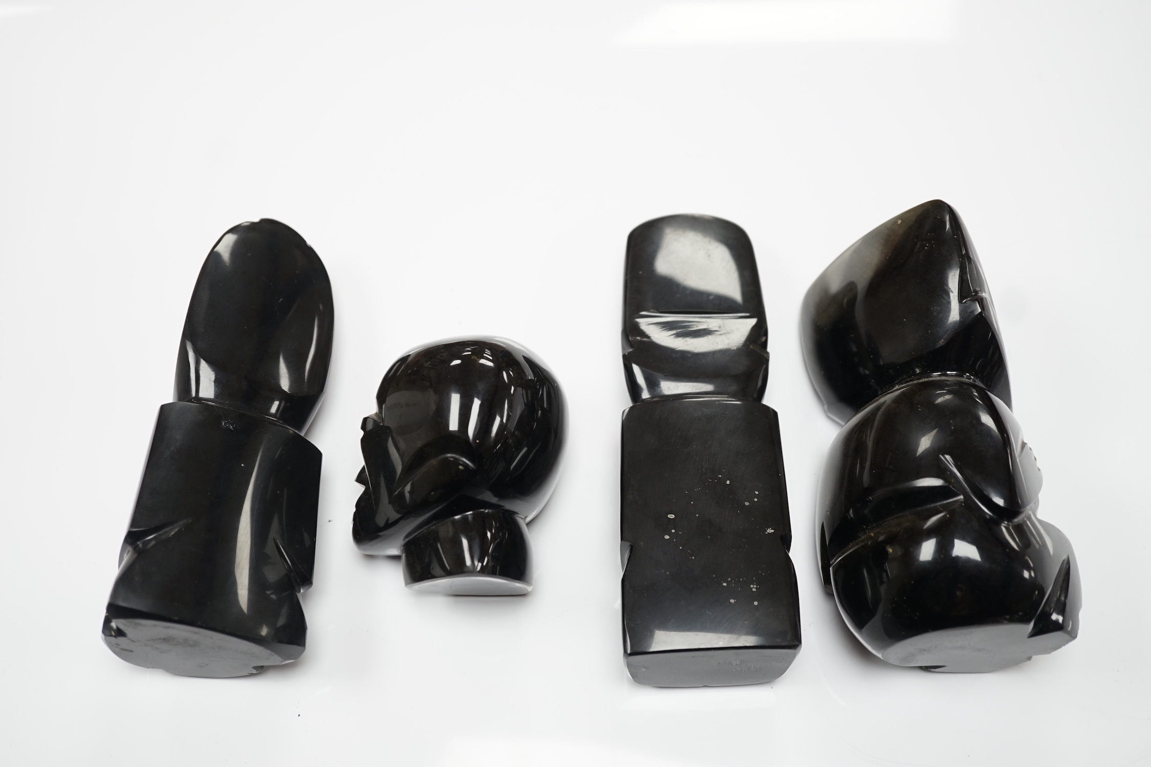 Three 20th century Aztec Mayan style carved obsidian stylised figures and a similar mask (4) tallest 15cm